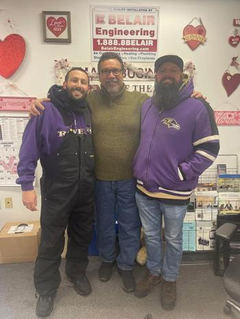 Group picture of three of Belair'S top employees sharing a moment in front of Belair business sign.
